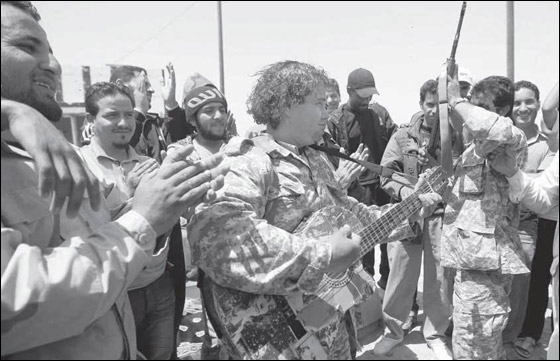 عازف غيتار ومقاتل ليبي يغني لثورة ليبيا في ساحات المعارك!! صورة رقم 2 عازف غيتار ومقاتل ليبي يغني لثورة ليبيا في ساحات المعارك!! صورة رقم 2