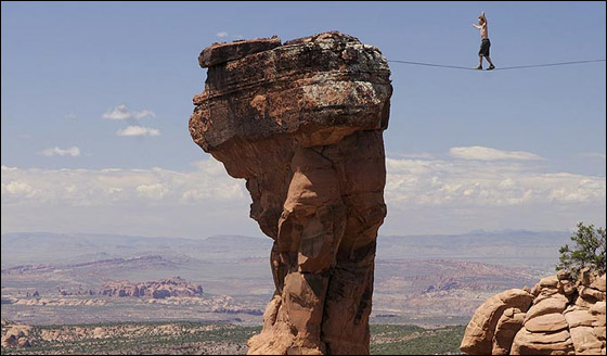 دون وسائل امان: مغامر يمشي على حبل رفيع مع ابتسامة عريضة  صورة رقم 1