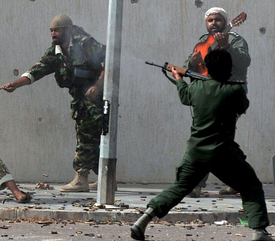 مقاتل ليبي يعزف الجيتار بهدوء تام أثناء معركة سرت! صورة رقم 2