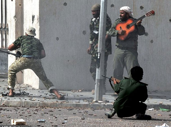 مقاتل ليبي يعزف الجيتار بهدوء تام أثناء معركة سرت! صورة رقم 1