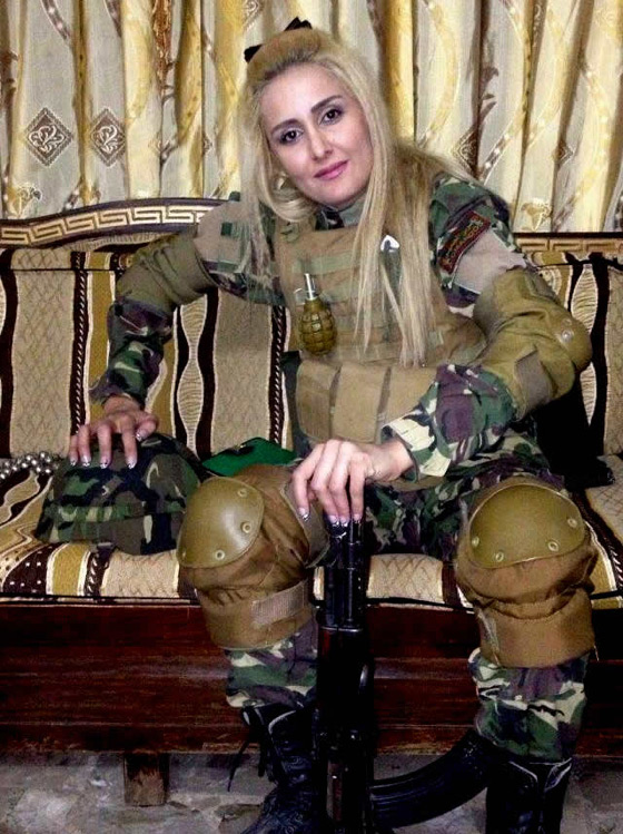 مذيعة تلفزيون سوري ترتدي البزة العسكرية وتشهر السلاح صورة رقم 2