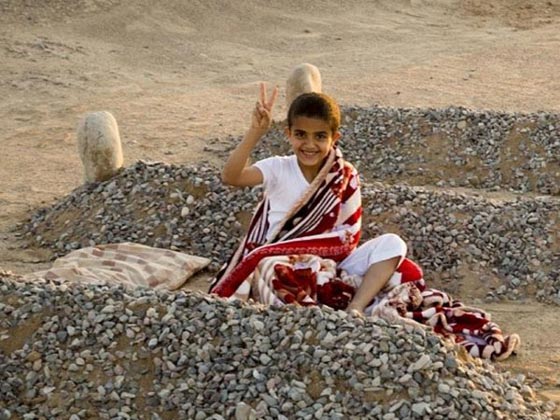 الحقيقة من وراء صورة الطفل الذي ينام بين قبرين وابكت العالم صورة رقم 1