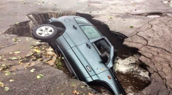  نجاة سائق باعجوبة بعد ان انشقت الارض تحت سيارته صورة رقم 1