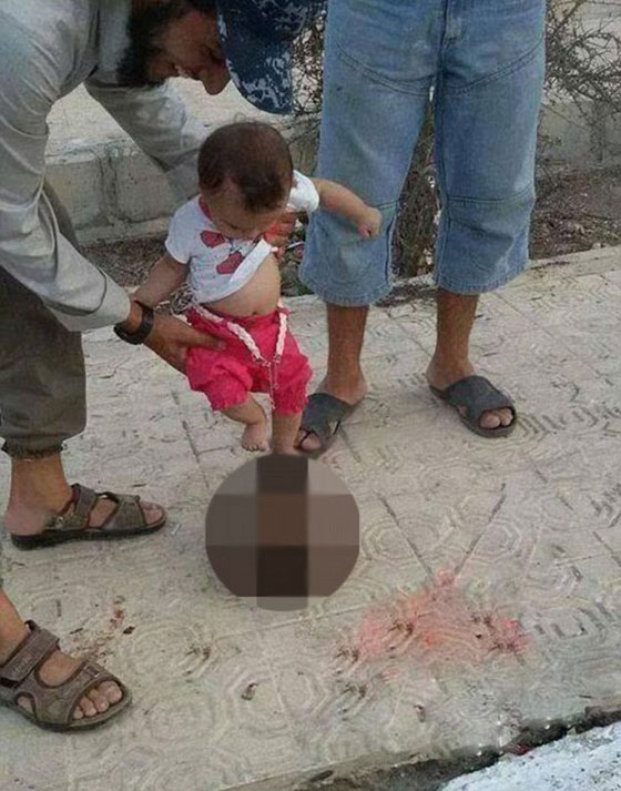مشهد مرعب.. طفل يركل راس رجل ذبحه الدواعش صورة رقم 1