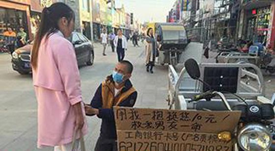 صور.. شابة صينية تعانق المارة لجمع المال وانقاذ صديقها المريض صورة رقم 1