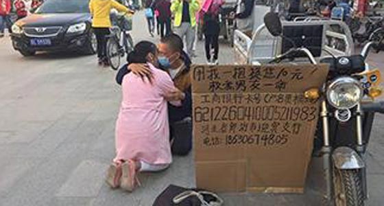 صور.. شابة صينية تعانق المارة لجمع المال وانقاذ صديقها المريض صورة رقم 4