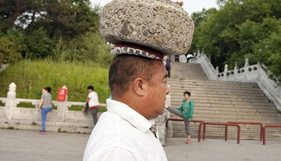  صور رجل صيني يتجول بصخرة على راسه لكي يخسر وزنه صورة رقم 1