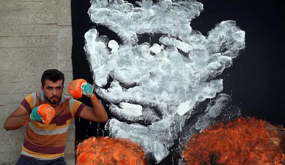 فنان فلسطيني يرسم جدارية محمد علي كلاي باستخدام قفازات ملاكمة صورة رقم 2