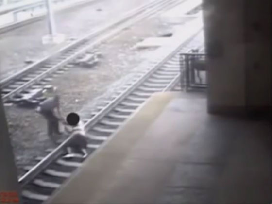 شرطي شجاع يسحب رجلا عن سكة حديد قبل ثانية من مرور القطار صورة رقم 2