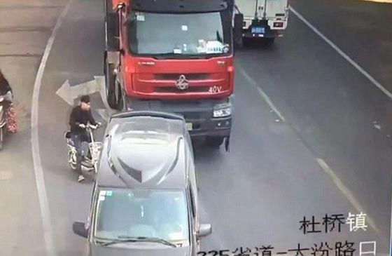 فيديو وصور: سائق دراجة نارية متهور ينجو من الموت سحقا بعجلات شاحنة صورة رقم 2