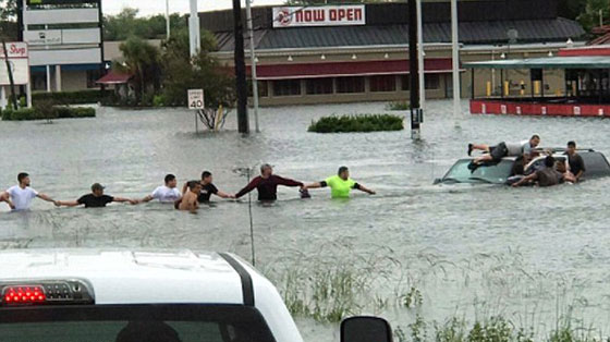 فيديو وصور.. سلسلة بشرية لانقاذ رجل مسن جرفته مياه الفيضانات صورة رقم 1