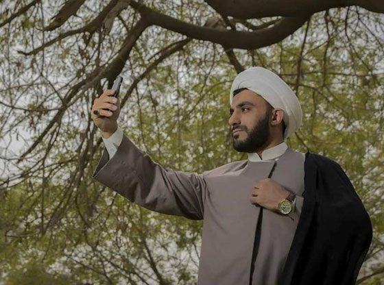 رجل دين عراقي في صور غير تقليديه: يبرز عضلاته  ويتصور سيلفي! صورة رقم 2