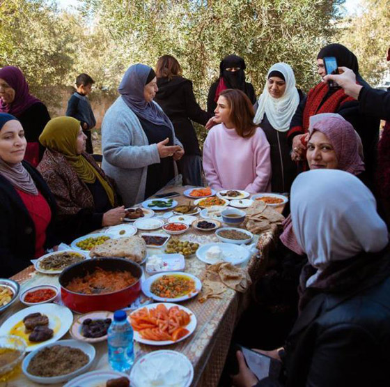 صور الملكة رانيا جالسة على الارض بجوار فرن الخبيز لتشجيع المتطوعات صورة رقم 4