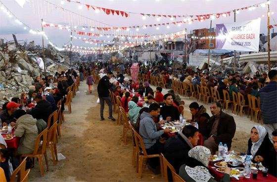 إفطار وسط الركام.. فلسطينيون يحتفلون بأول أيام رمضان بمائدة جماعية صورة رقم 4