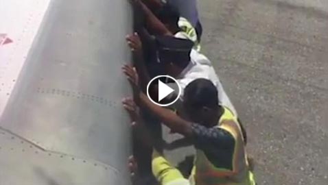 بالفيديو: رجال يدفعون طائرة.. والركاب يصورون 