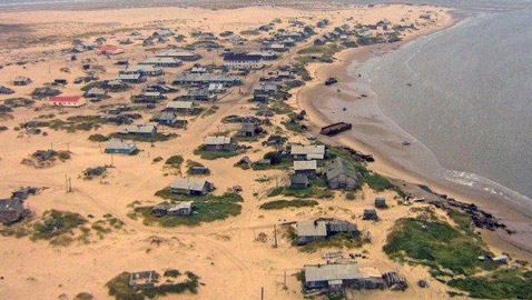 صور قرية روسية غارقة بالرمال وسكانها يدخلون بيوتهم من الأسطح