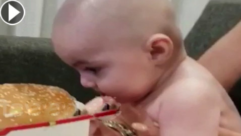 فيديو طريف.. طفلة رضيعة جائعة تحاول تناول وجبة هامبورجر (بيغ ماك)!